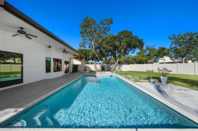 view of pool with ceiling fan, a patio area, and a yard