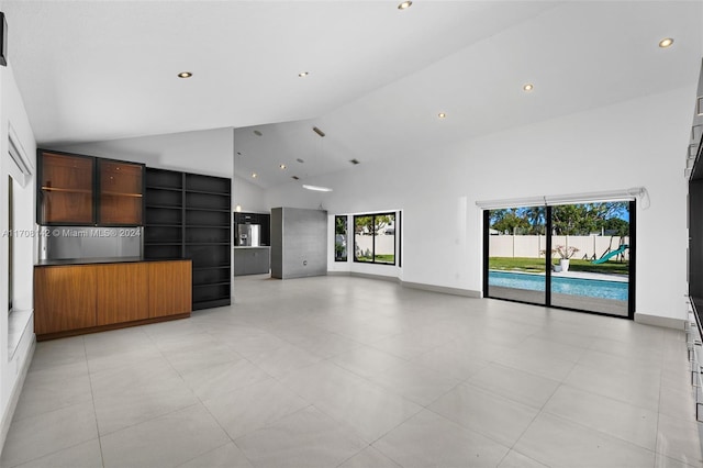 unfurnished living room featuring high vaulted ceiling