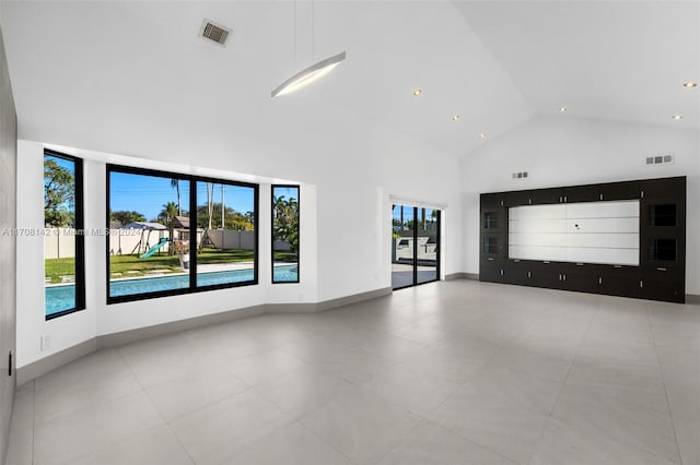 unfurnished living room with a wealth of natural light and high vaulted ceiling