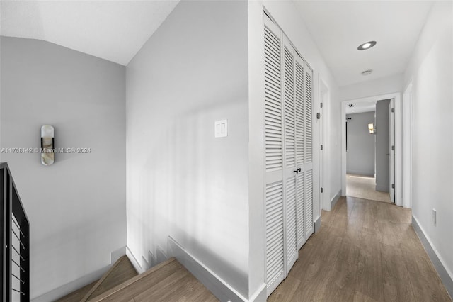 hallway with hardwood / wood-style floors and lofted ceiling