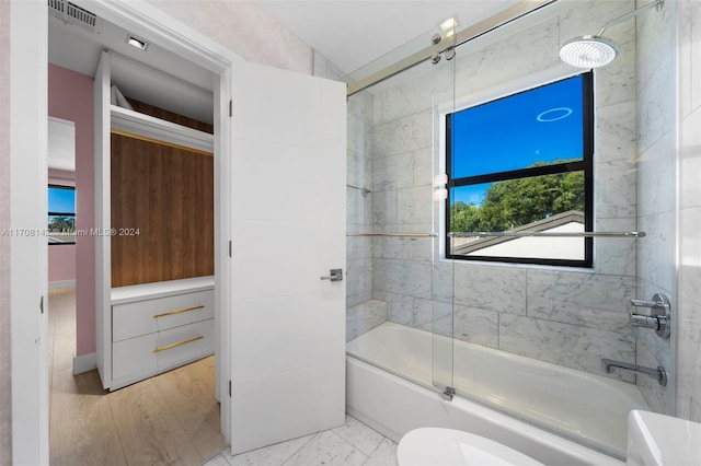 bathroom featuring toilet, enclosed tub / shower combo, and vaulted ceiling