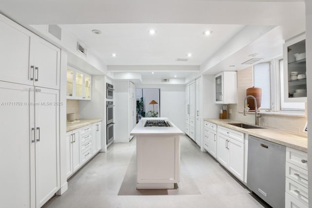 kitchen with white cabinetry, sink, stainless steel appliances, and a center island