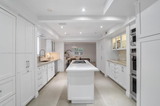 kitchen with white cabinets, sink, and a kitchen island