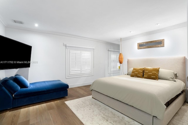 bedroom with crown molding and hardwood / wood-style floors