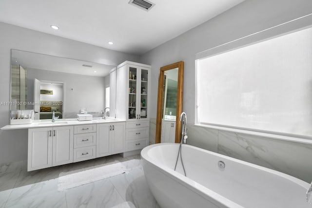 bathroom featuring vanity and a bath