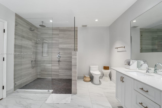 bathroom featuring toilet, a shower with door, and vanity