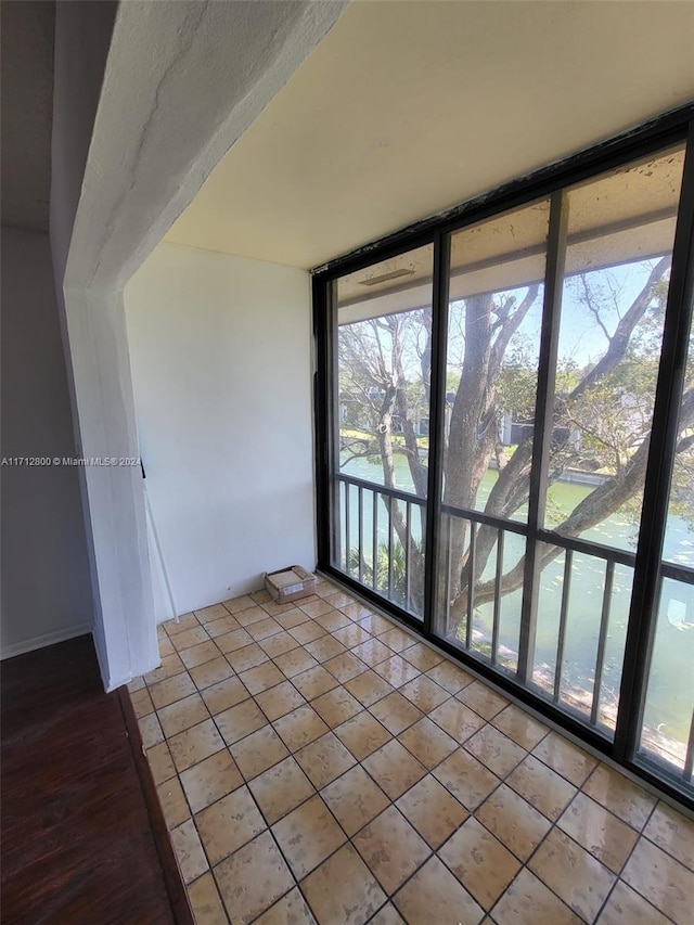 spare room with floor to ceiling windows and light tile patterned floors