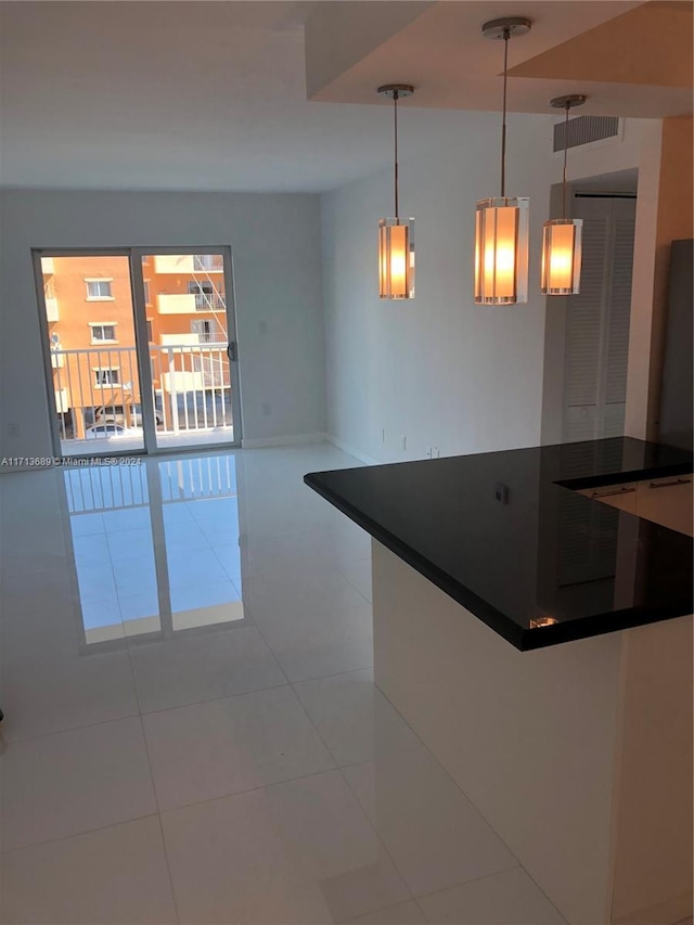 kitchen with light tile patterned floors and decorative light fixtures