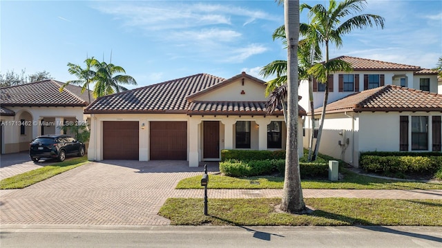 mediterranean / spanish-style house featuring a garage and a front lawn