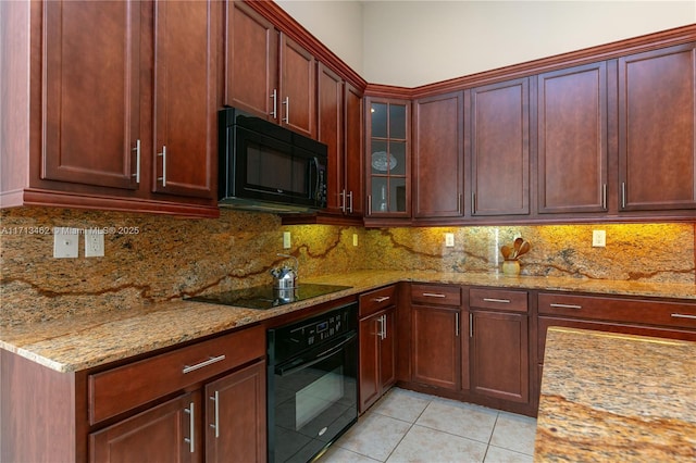 kitchen featuring light stone countertops, backsplash, black appliances, and light tile patterned flooring