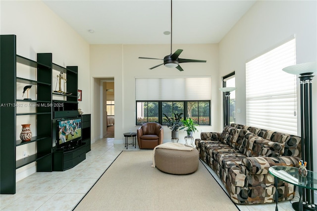 living room featuring a high ceiling, light tile patterned flooring, and ceiling fan