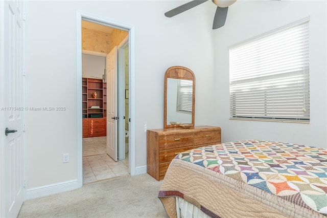 bedroom with ceiling fan, a spacious closet, light colored carpet, and a closet