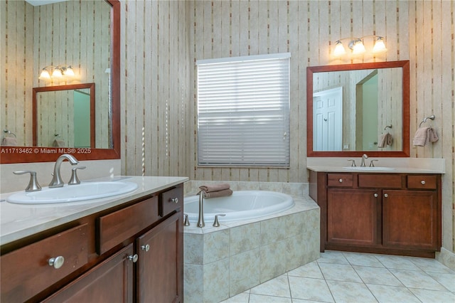 bathroom featuring a relaxing tiled tub, vanity, and tile patterned flooring