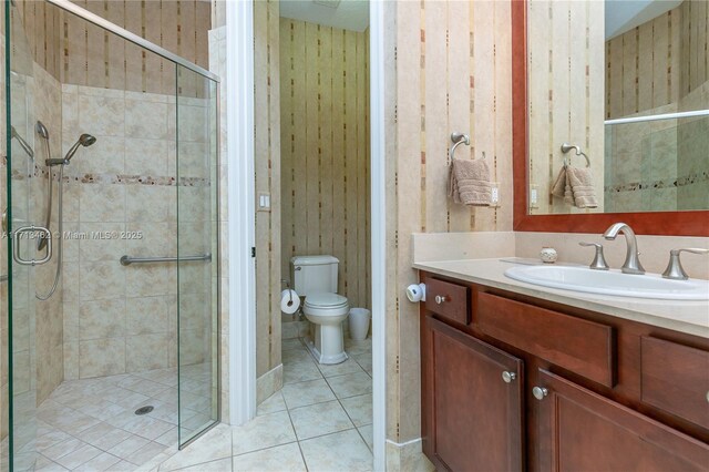 bathroom featuring an enclosed shower, vanity, tile patterned floors, and toilet