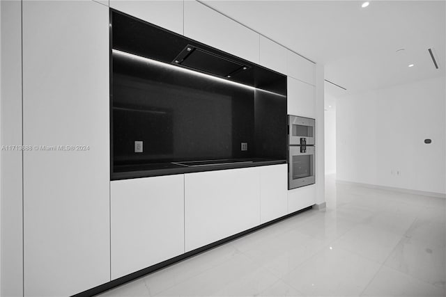 kitchen featuring white cabinetry, black electric stovetop, and double wall oven