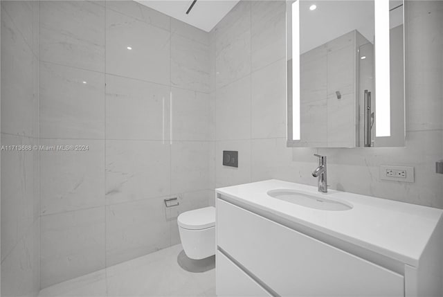 bathroom with vanity, toilet, and tile walls