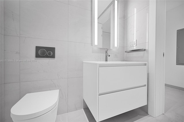 bathroom with vanity, toilet, and tile walls