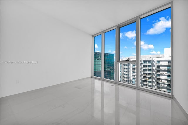 unfurnished room featuring floor to ceiling windows and light tile patterned floors