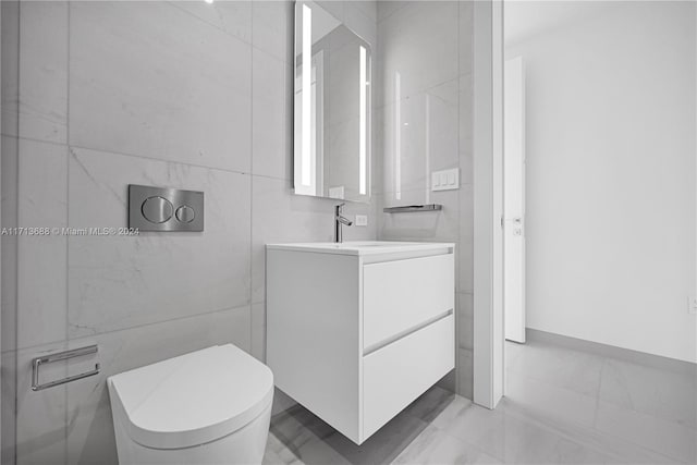 bathroom featuring vanity, tile walls, and toilet