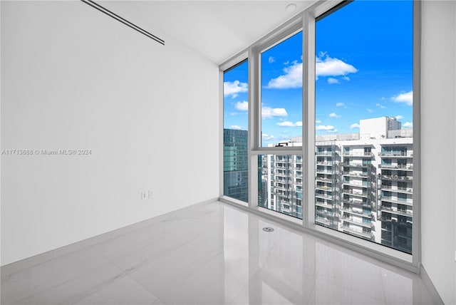 empty room with tile patterned floors and floor to ceiling windows