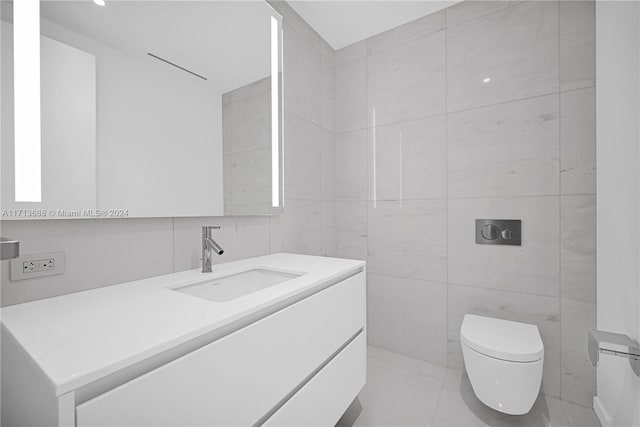 bathroom with vanity, tile walls, and toilet