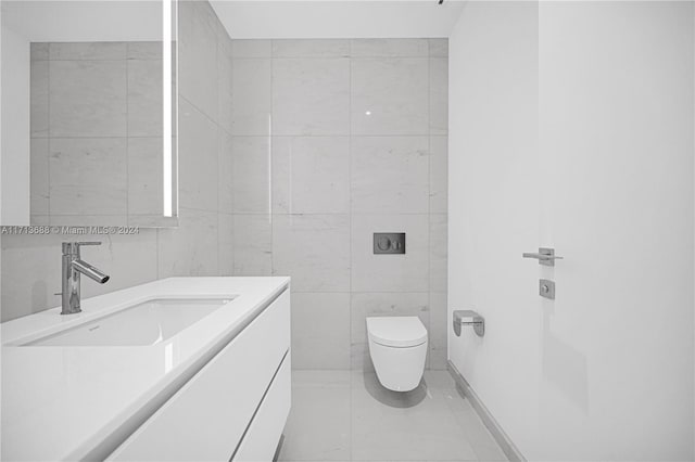 bathroom featuring tile patterned floors, vanity, toilet, and tile walls