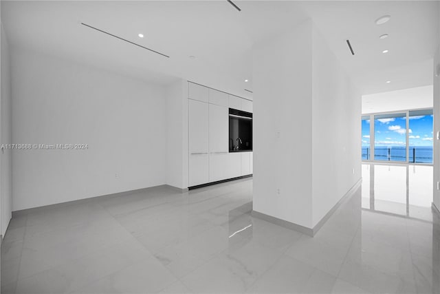 empty room featuring a water view and floor to ceiling windows