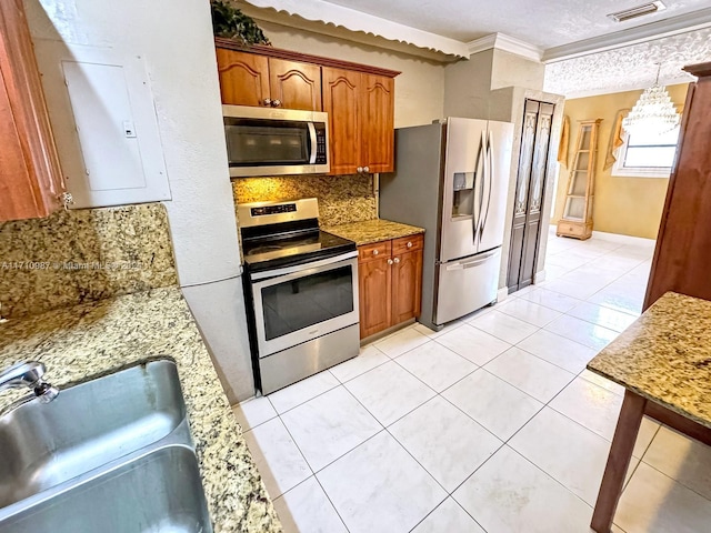 kitchen with sink, ornamental molding, tasteful backsplash, decorative light fixtures, and stainless steel appliances