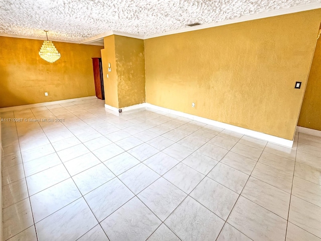 empty room featuring a chandelier, tile patterned floors, and ornamental molding