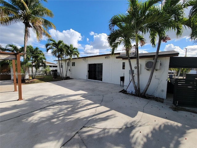 back of property featuring a carport and central AC