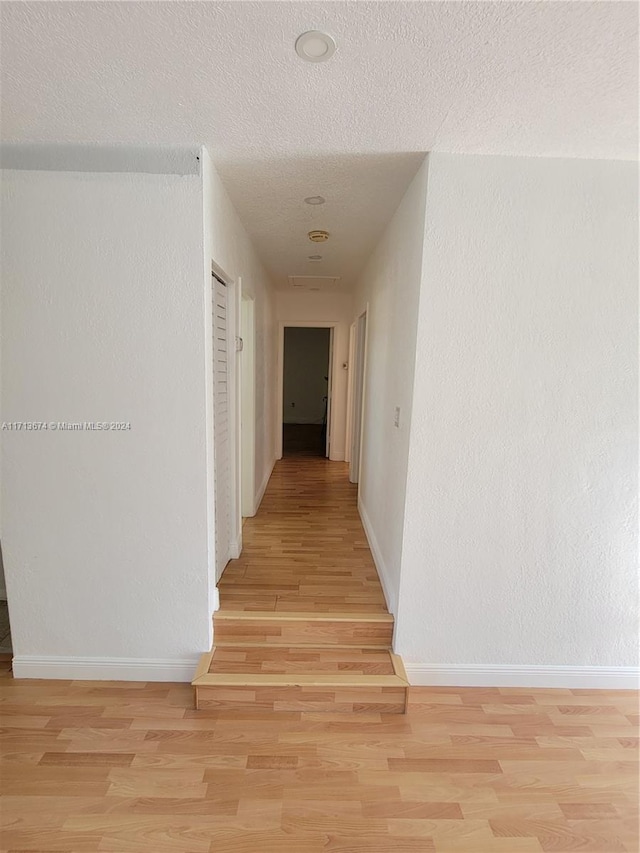 hallway with light hardwood / wood-style floors