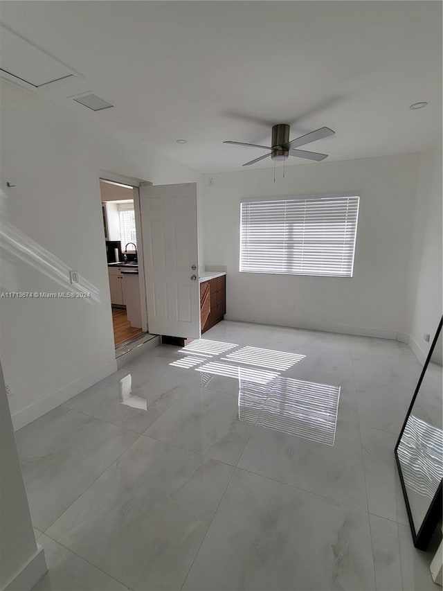 unfurnished room with ceiling fan and sink