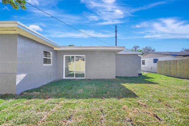 rear view of property featuring a yard