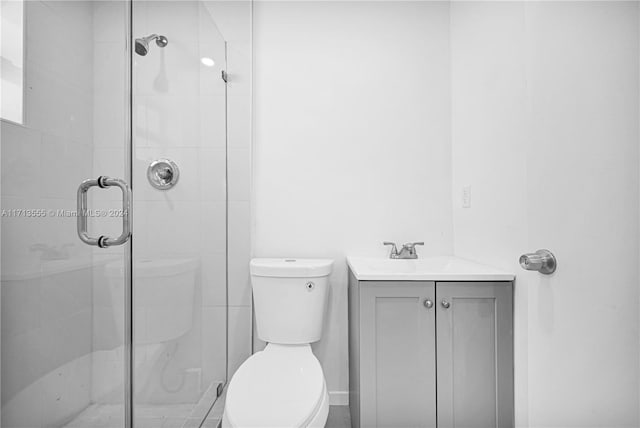 bathroom featuring vanity, toilet, and a shower with door