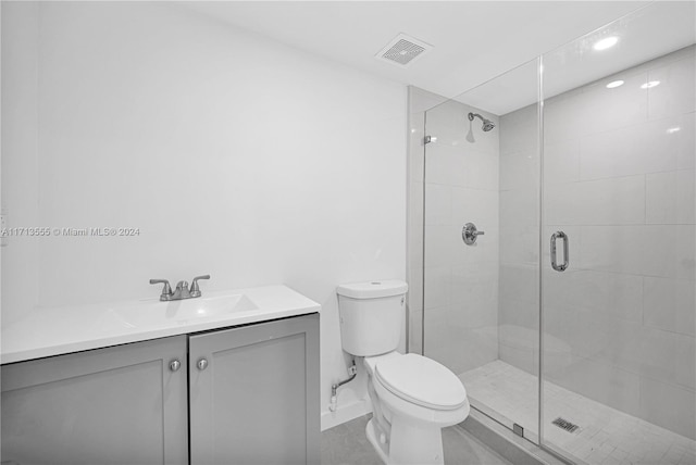 bathroom with vanity, toilet, and a shower with shower door