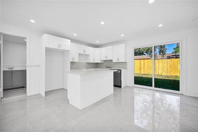 kitchen featuring white cabinets, decorative backsplash, a center island, and stainless steel dishwasher