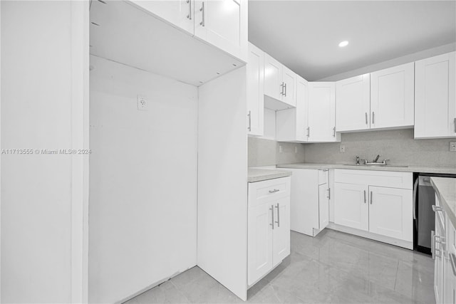 kitchen featuring dishwasher, white cabinetry, and sink