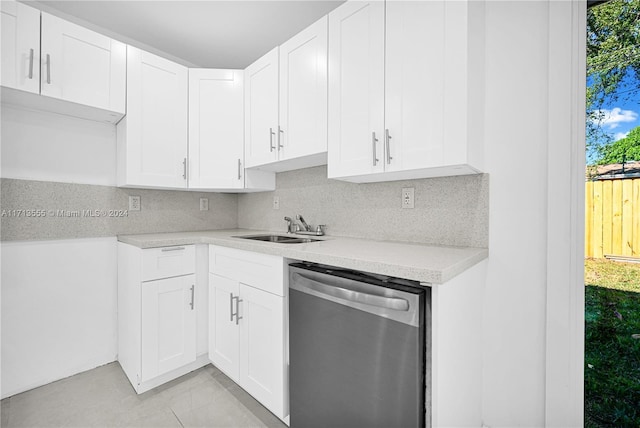 kitchen featuring stainless steel dishwasher, backsplash, white cabinets, and sink