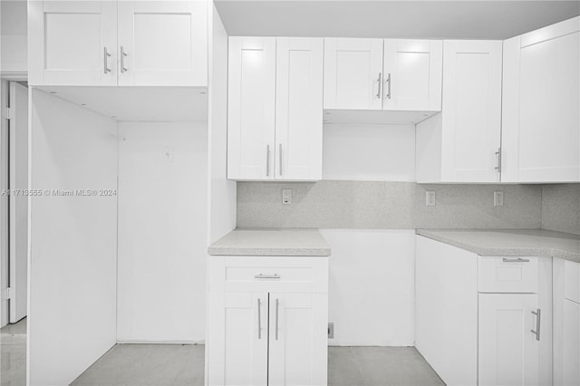 kitchen featuring tasteful backsplash and white cabinetry