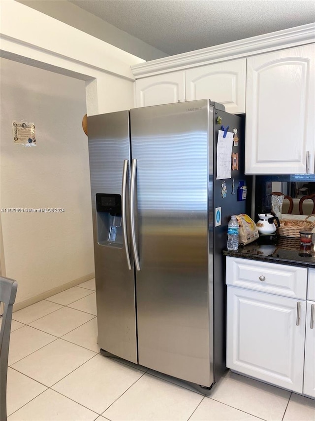 kitchen featuring white cabinets, stainless steel fridge with ice dispenser, a textured ceiling, and light tile patterned floors