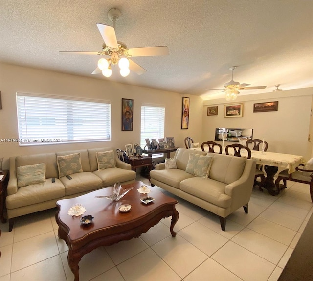 tiled living room with ceiling fan, plenty of natural light, and a textured ceiling