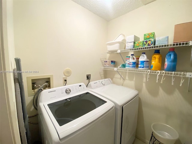 laundry area featuring washing machine and dryer and a textured ceiling