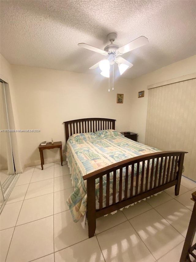 bedroom with light tile patterned floors, a textured ceiling, and ceiling fan