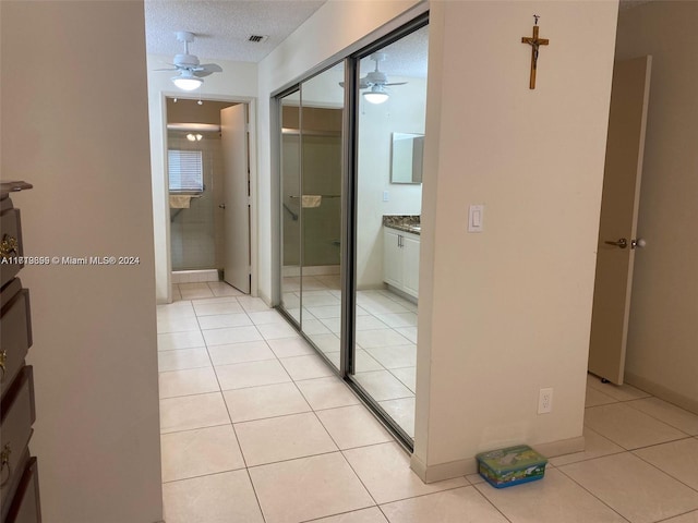 hall with light tile patterned floors and a textured ceiling