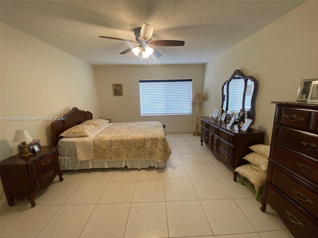 tiled bedroom with ceiling fan and a textured ceiling