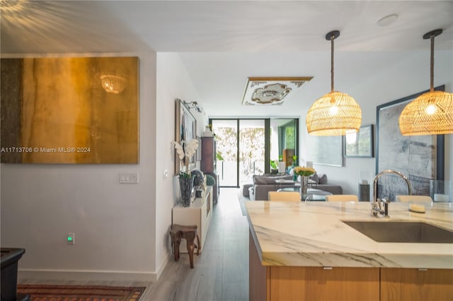 kitchen featuring hanging light fixtures, dark hardwood / wood-style floors, expansive windows, and sink