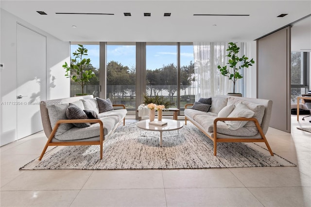 living room featuring light tile patterned flooring and a wall of windows