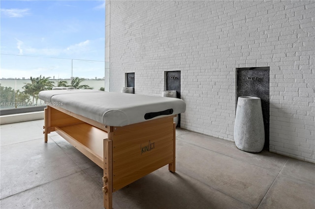 bedroom featuring brick wall