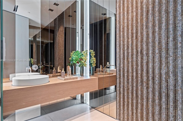 bathroom with tile patterned flooring, a shower with shower door, and sink