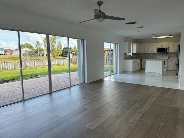 unfurnished living room with ceiling fan and light wood-type flooring